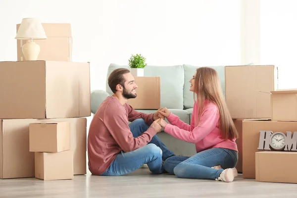 Mladý pár s stěhovací krabice na podlaze v pokoji — Stock fotografie