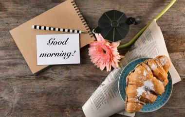 Lezzetli kruvasan kahvaltı için ve Günaydın ile kompozisyon dilek ahşap masa, üstten görünüm