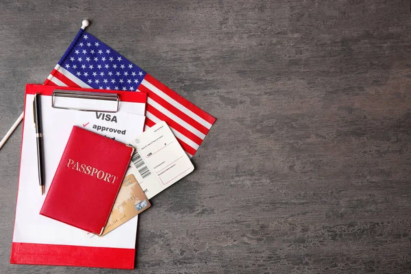 Passport, ticket, credit card and USA flag on table. Approved American visa