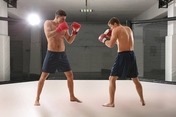 Два сильных боксера дерутся в спортзале
