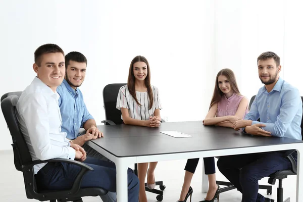 Jovens sentados juntos à mesa, dentro de casa. Conceito de unidade — Fotografia de Stock