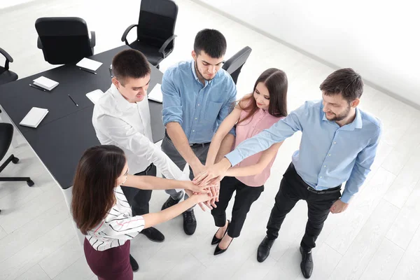 Unga människor att sätta händerna tillsammans, inomhus. Unity-konceptet — Stockfoto