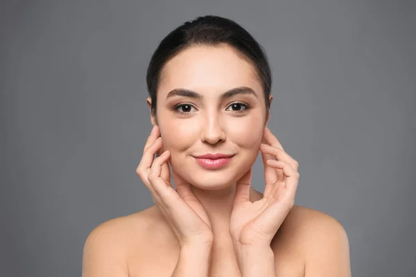 Portrait de belle jeune femme à la peau claire sur fond gris — Photo