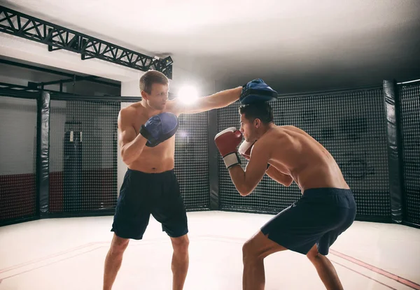 Entrenamiento de boxeador joven en gimnasio con entrenador personal — Foto de Stock