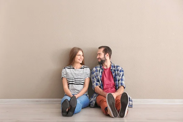 Νεαρό ζευγάρι κάθεται στο πάτωμα στο άδειο δωμάτιο. Έτοιμοι για τη μετάβαση σε νέο σπίτι — Φωτογραφία Αρχείου