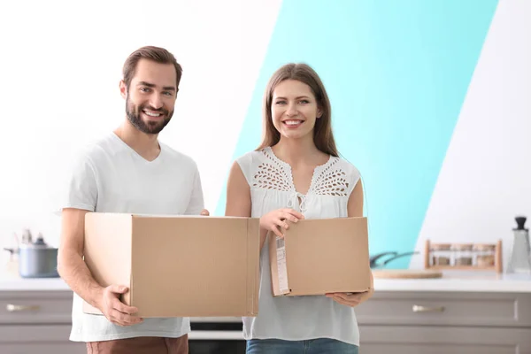 Pareja joven con cajas adentro. Día en movimiento —  Fotos de Stock