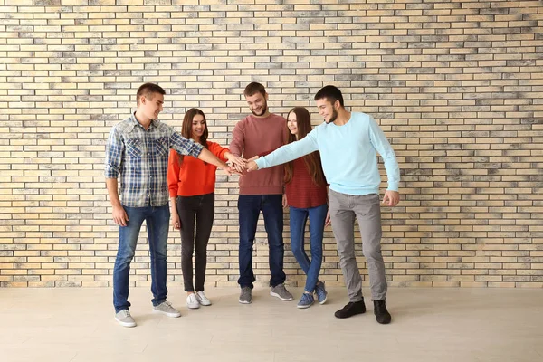 Gente poniendo manos juntas, adentro. Concepto de unidad — Foto de Stock