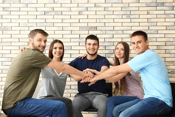Människor att sätta händerna tillsammans, inomhus. Unity-konceptet — Stockfoto