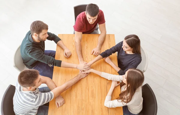 Gente cogida de la mano en la mesa. Concepto de unidad —  Fotos de Stock