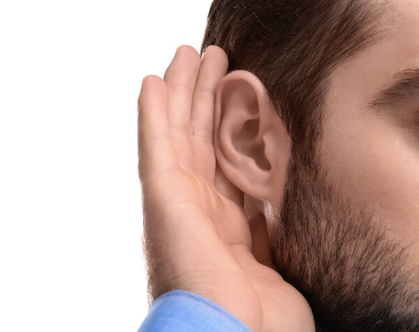 Молодой человек с проблемами со слухом на белом фоне, крупный план