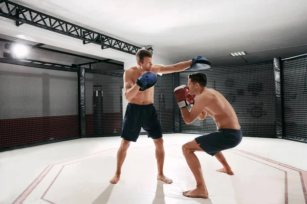 Treinamento de pugilista jovem em ginásio com treinador pessoal — Fotografia de Stock