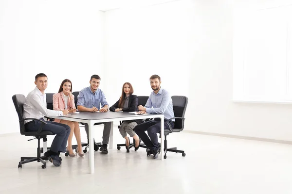 Junge Leute sitzen zusammen am Tisch, drinnen. Einheitskonzept — Stockfoto