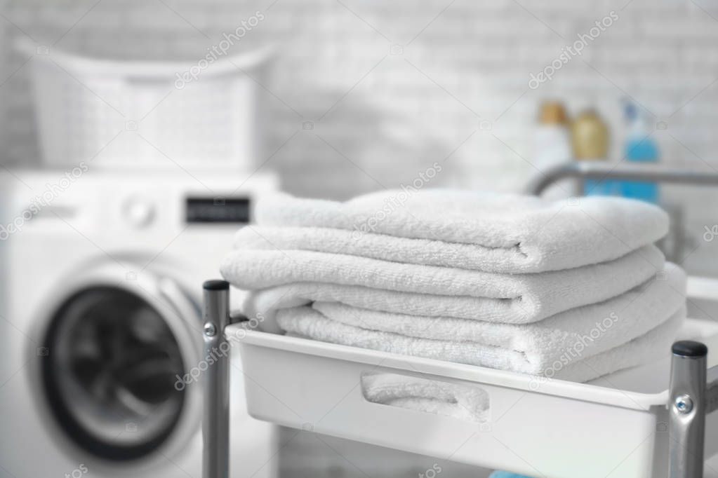 Stack of clean towels on cart in laundromat