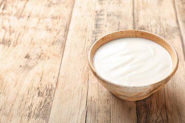 Ahşap masa üzerinde tabak lezzetli yoğurt