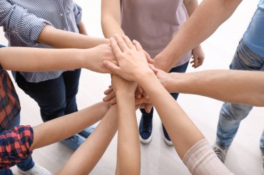 Young people putting hands together as symbol of unity clipart