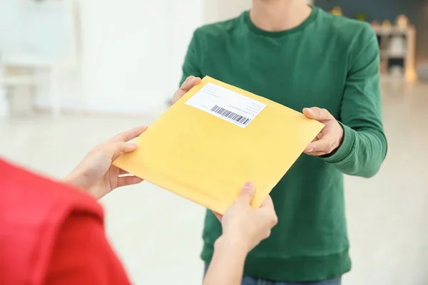 Man tar emot paket från courier inomhus — Stockfoto