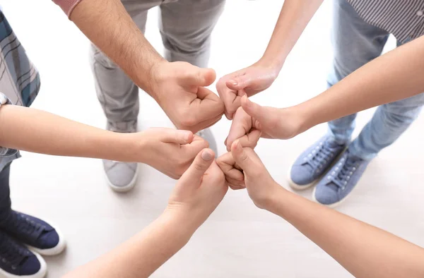 Mladí lidé stojící v kruhu a ukazuje palcem nahoru gesto jako symbol jednoty — Stock fotografie
