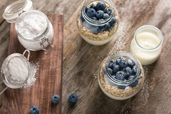 Yoghurt met Haver vlokken en bosbes in potten op houten tafel — Stockfoto