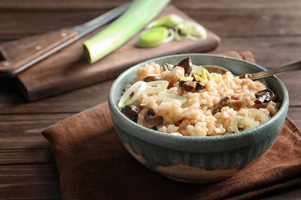 Skål med läcker risotto och svamp på bord — Stockfoto