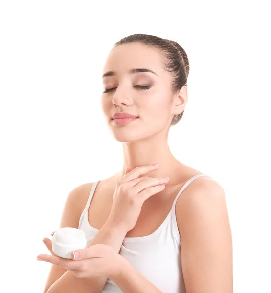 Mujer joven aplicando crema corporal sobre fondo blanco — Foto de Stock