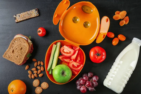 Voedsel voor scholier en lunch box op donkere achtergrond — Stockfoto