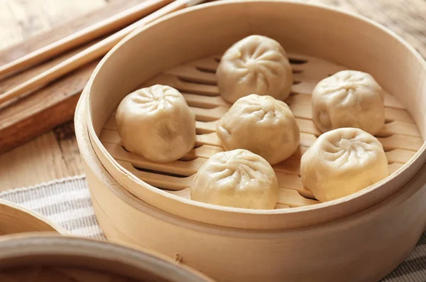 Bamboe stomer met de smakelijke Bapao dumplings op tafel — Stockfoto