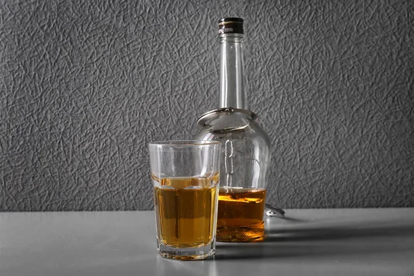 Glas och flaska alkohol med handklovar på bord — Stockfoto