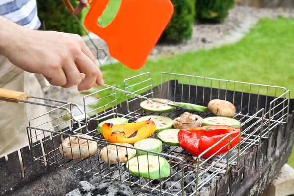 Férfi főzés lédús zöldséget barbecue grill — Stock Fotó