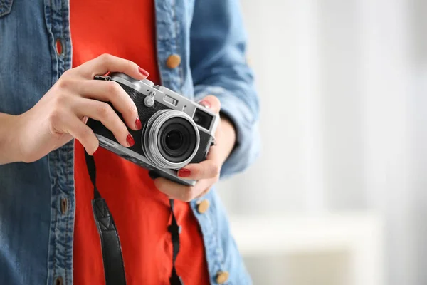 Young photographer with camera, indoors — Stock Photo, Image