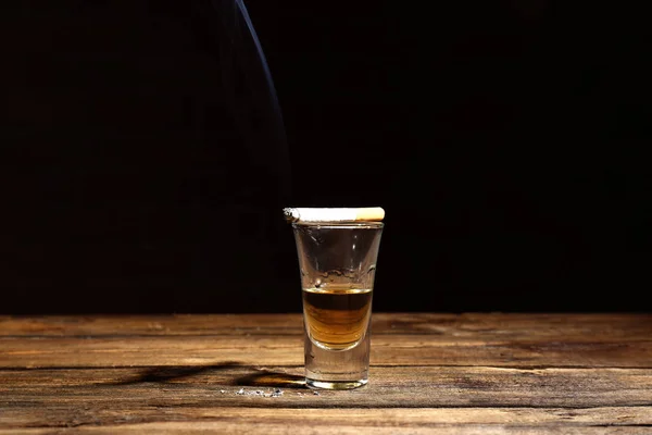 Glas Alkohol und Zigarette auf dem Tisch — Stockfoto