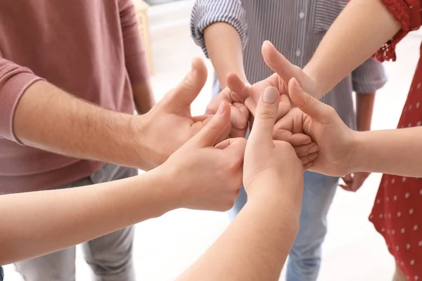 Jóvenes de pie en círculo y mostrando gesto de pulgar hacia arriba como símbolo de unidad —  Fotos de Stock