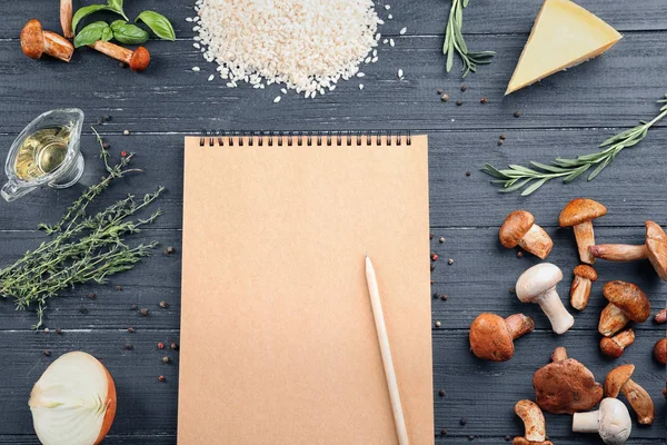 Cuaderno e ingredientes para risotto con setas sobre fondo de madera — Foto de Stock