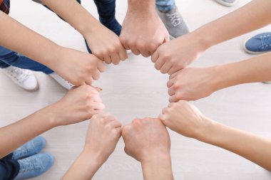 Gençlerin kendi yumruklarını birlikte daire içinde birlik sembolü olarak koyarak.