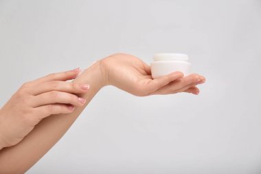 Kadın vücut kremi ışık arka plan üzerinde uygulama