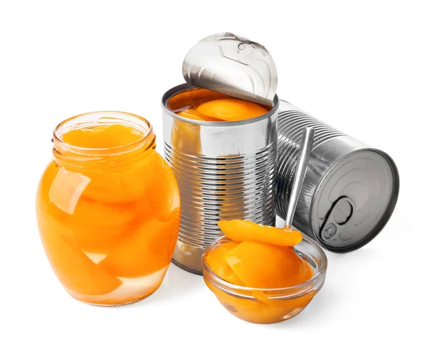 Plechovky, džbán a mísa s nakládanými meruňky na bílém pozadí — Stock fotografie