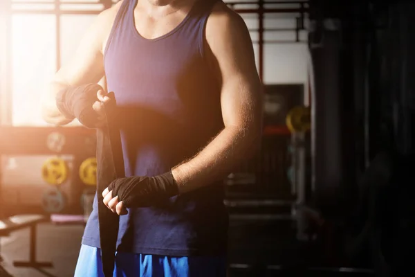 Boxeador aplicando envolturas de mano mientras se prepara para el entrenamiento en gimnasio —  Fotos de Stock