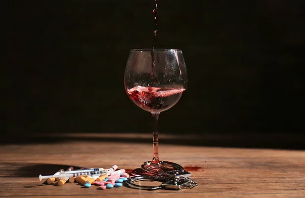 Composition with wine, drugs and handcuffs on table. Alcoholism and drug addiction — Stock Photo, Image