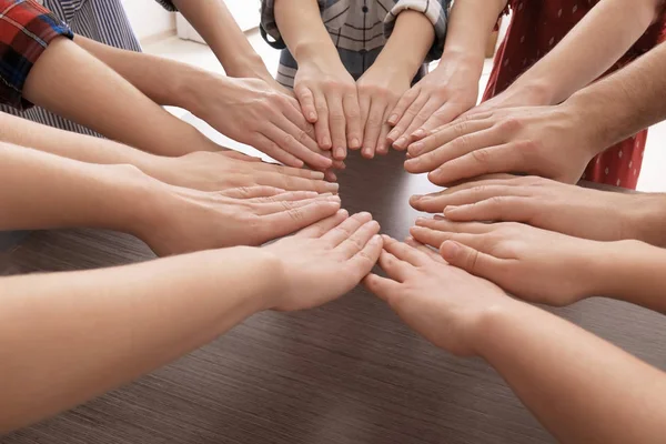 Unga människor sätta händerna tillsammans i cirkel som symbol för enighet — Stockfoto
