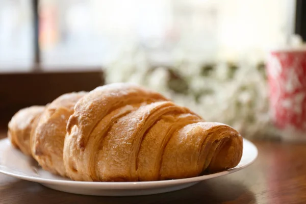 Deska s croissanty k snídani na stole, closeup — Stock fotografie