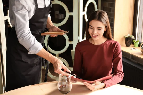 Camarero ayudando a la joven a hacer orden en el restaurante — Foto de Stock