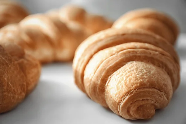 Sabrosos croissants sobre fondo claro, primer plano — Foto de Stock