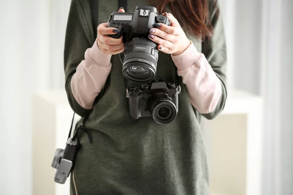 Jovem fotógrafo com câmeras, dentro de casa — Fotografia de Stock
