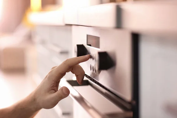 Homem ajustando forno elétrico na cozinha, close-up — Fotografia de Stock