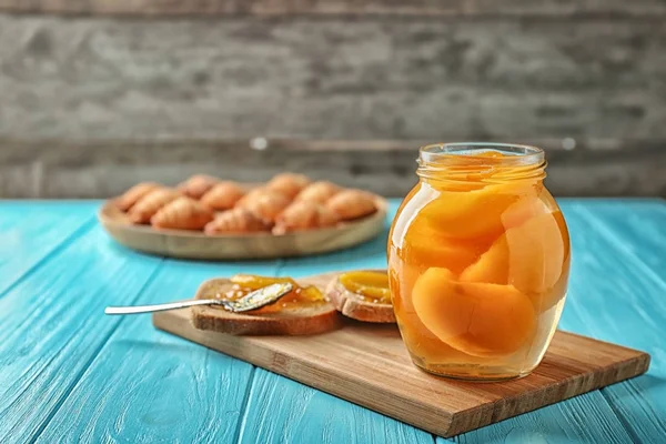 Tarro con albaricoques en vinagre sobre tabla de madera — Foto de Stock