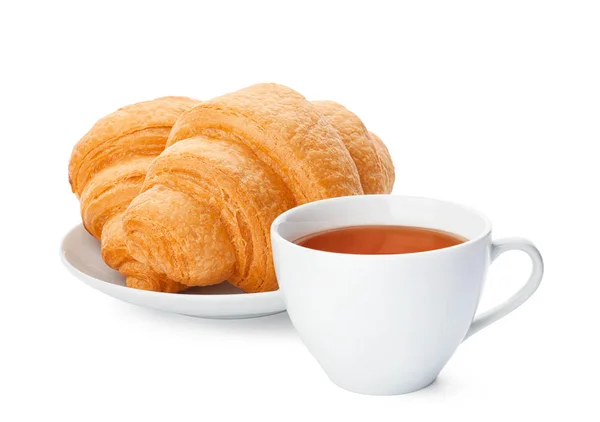 Croissants saborosos e xícara de chá no fundo branco — Fotografia de Stock