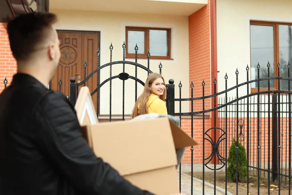 Jong (echt) paar met kartonnen dozen in de buurt van hun nieuwe huis over het verplaatsen van de dag — Stockfoto