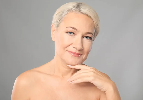 Retrato de bela mulher madura em fundo cinza. Conceito de cuidados da pele — Fotografia de Stock
