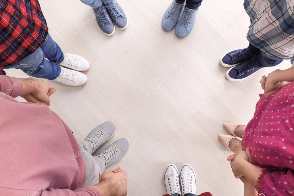 Group of people standing in circle and holding hands. Unity concept