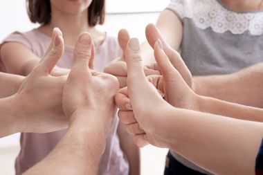 Grup daire içinde duran ve başparmak-up jest gösterilen insan. Birlik kavramı