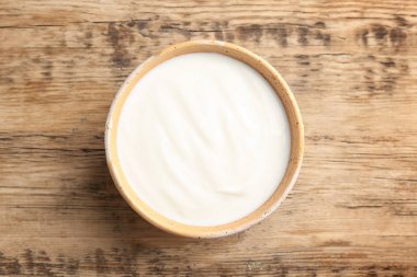 Ahşap masa üzerinde tabak lezzetli yoğurt